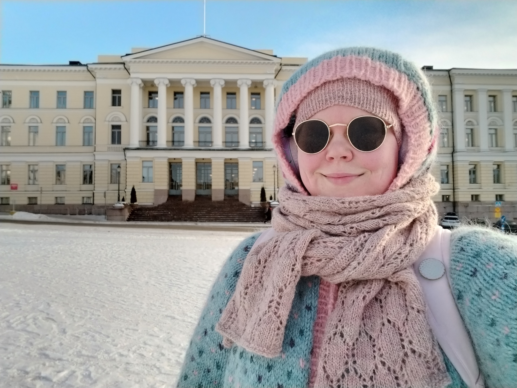 Hörhelöinen neulevaatteissa Helsingin yliopiston päärakennuksen edessä talvella.